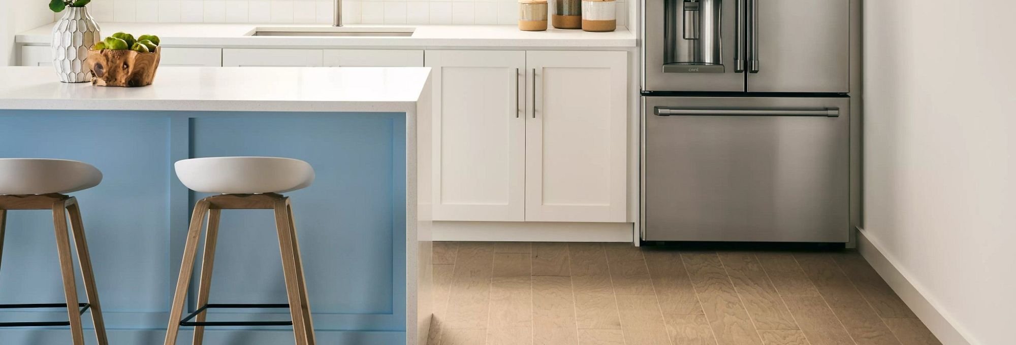 Kitchen with a fridge and some chairs on a brown hardwood floor from Howard Carpenter Floor Covering in Danville KY