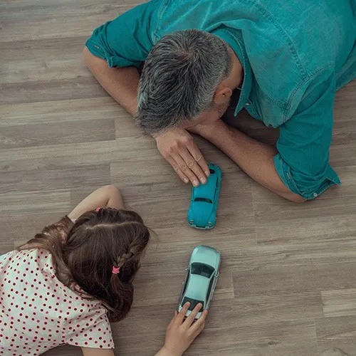 Girl and father playing with toy cars | Howard-Carpenter Floor Covering