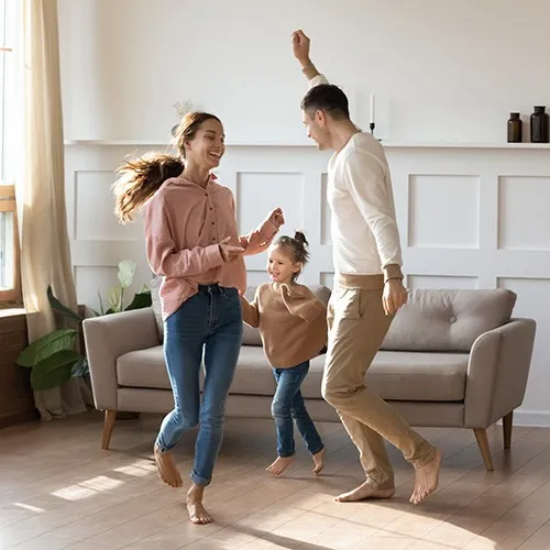 Family playing in living room | Howard-Carpenter Floor Covering