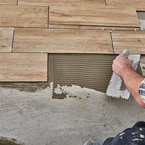 Worker installing tile | Howard-Carpenter Floor Covering